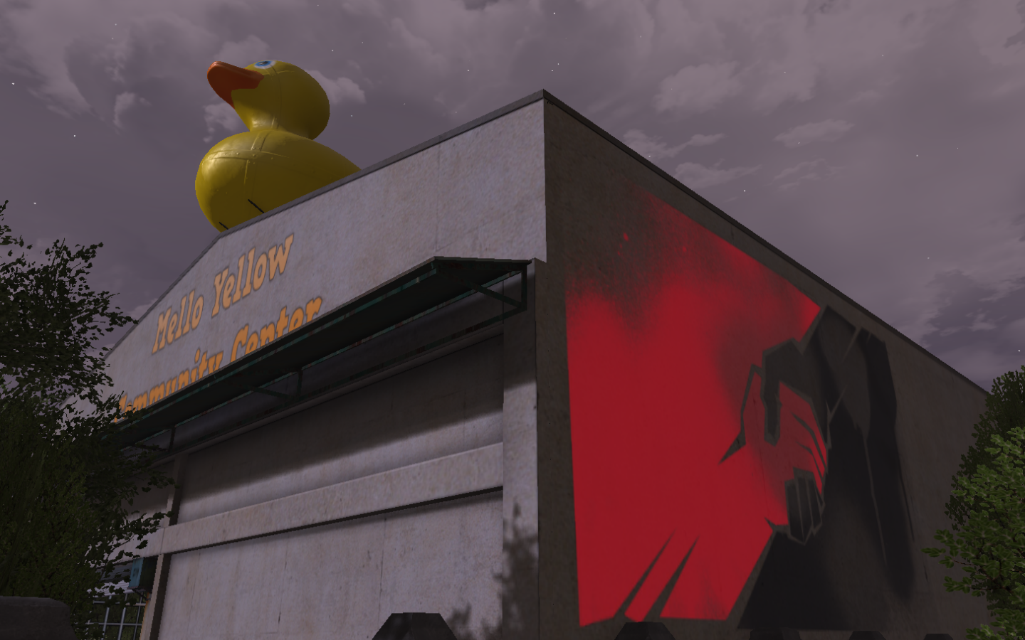 a tall commercial shed style building with a huge statue of a rubber ducky at the peak of its roof. the name of the venue is painted directly on the siding. on the adjacent side of the building is a large mural of hands clasping along the diagonal, with red on one side and black on the other.